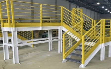 Steel mezzanine platform and staircase with yellow safety railings